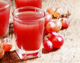 Fototapeta na wymiar Grape juice pink grapes with fresh berries, selective focus