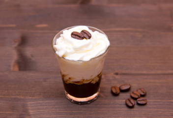 Glass with coffee and cream on wooden table