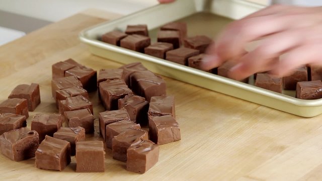Chocolate fudge being placed on baking tray