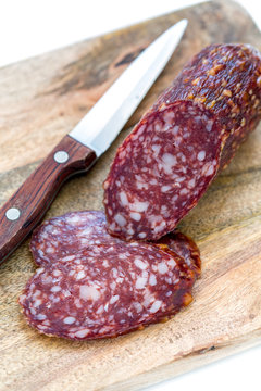 Sliced dry sausage and knife.