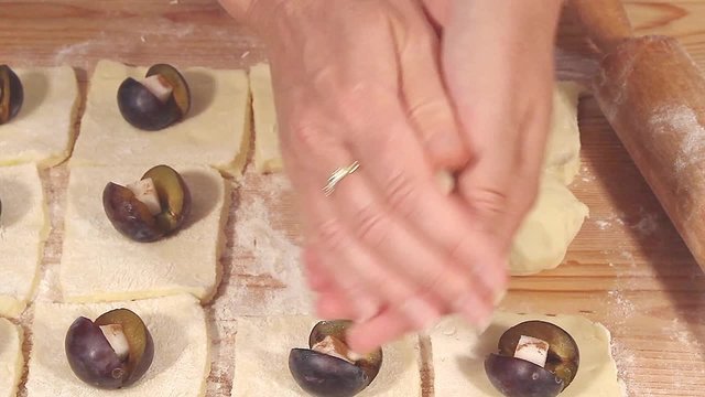 Plum dumplings being made: the plums being wrapped in dough