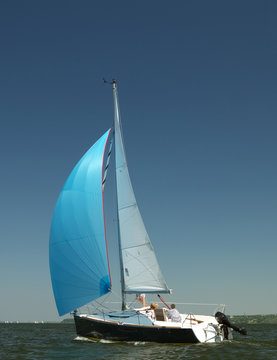 small yacht with blue sail