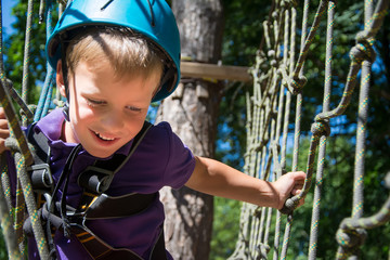 Five year boy on rope-way in forest