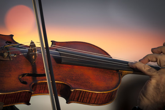 Primo piano di un violino suonato nella luce dell'alba