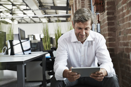 Businessman in office looking at digital tablet