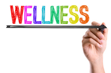 Hand with marker writing the word Wellness