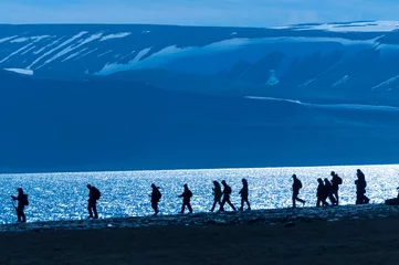Fotobehang Gesilhouetteerde groep wandelaars in Barentsoya, Svalbard, Noorwegen. © Don Landwehrle
