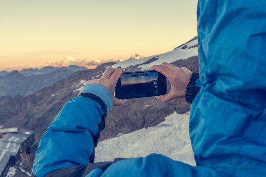 Woman taking a mountain photo with her phone.