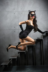 sexy woman in catwoman suit lying on stairs