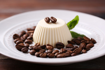 Tasty panna cotta dessert on plate, on wooden table