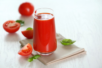 Tomato juice and fresh tomatoes on wooden table close-up