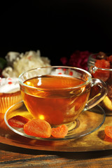 Composition with cup of herbal tea, dried apricots and peony flowers on wooden background