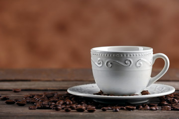 Cup of coffee and beans on blurred background