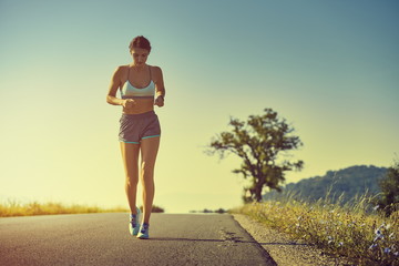 Running woman at sunrise or sunset