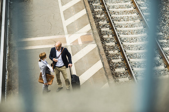 Businessman and businesswoman talking on railway platform