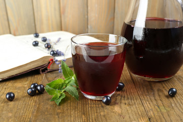 Fresh currant juice with berries and book on table close up