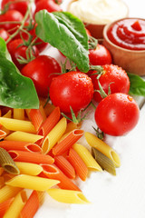 Pasta penne with tomatoes, cheese and basil on color wooden  background