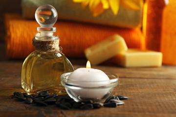 Obraz na płótnie Canvas Massage oil and spa treatments, sunflower on wooden background