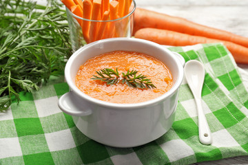 Carrot cream-soup with vegetables on table close up