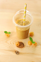 Cup of raspberry smoothie on wooden background