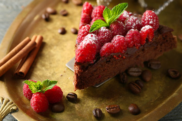 Piece of cake with Chocolate Glaze and raspberries on tray, close-up