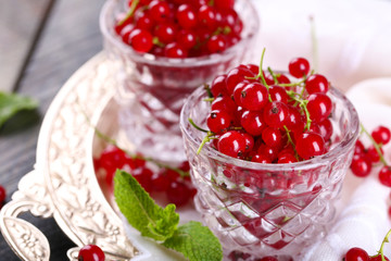 Fresh red currants in glasses on table close up