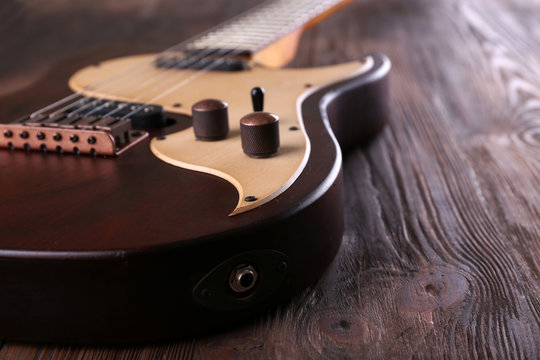 Electric guitar on wooden table close up
