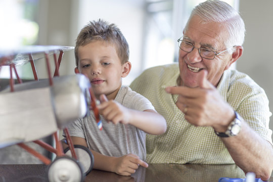 Grandfather and grandson building up a model airplane