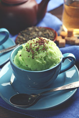 Homemade Green tea ice-cream in cup, on wooden background