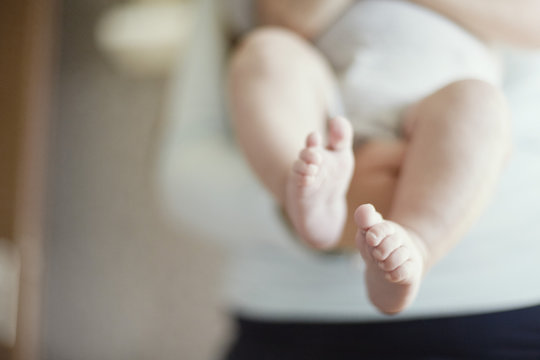 Feet of baby being held by mother