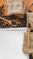 White notebook for your text with sackcloth and coffee beans on
