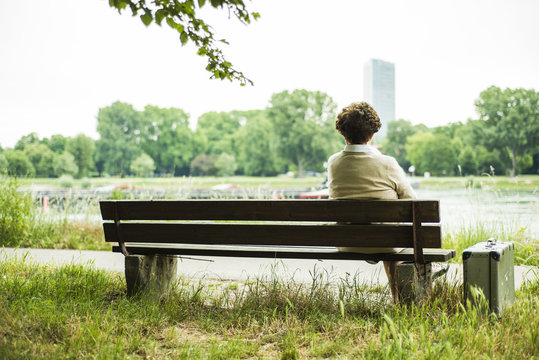 Back view of senior woman sitting on a bench