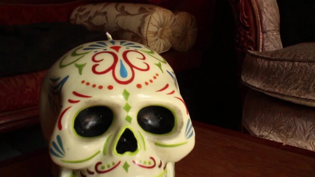 Dolly out from hand painted Mexican skull with medium depth of field; hold on medium close up