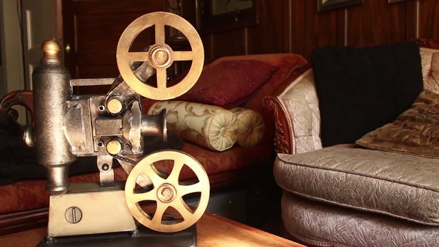 VINTAGE MOVIE PROJECTOR (DOLLY MOVE) with Antique Furniture in Background - Start with medium shot, move in to Medium close up; return to first position