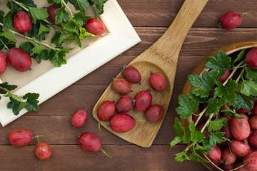 Ripe gooseberries in a wooden spoon on the table