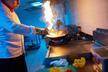 Fototapeta na wymiar chef in hotel kitchen prepare food with fire