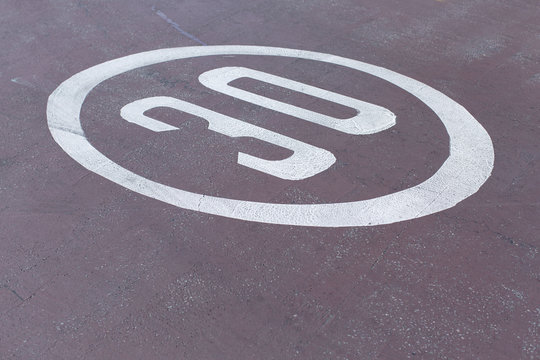 30mph or kmh road sign on the ground at an abstract angle