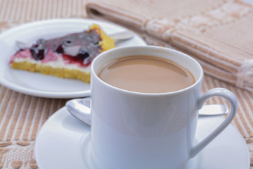 Coffee and dessert on brown table cloth.