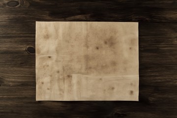 sheet old vintage paper on the aged wooden background. Parchment