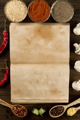 open old vintage book with spices on wooden background. Healthy vegetarian food. Recipe, menu, mock up, cooking.