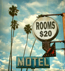 aged and worn vintage photo of motel rooms sign with palm trees