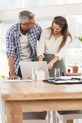 Laughing business colleagues using laptop