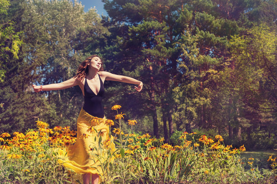 Girl Dancing in Nature Outdoor.  Freedom and Harmony Concept. Summer Sunny Day in Park Forest