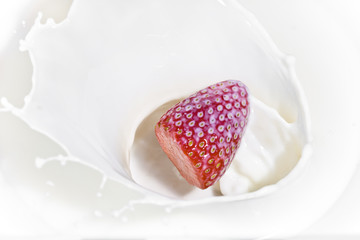 The strawberry falling in milk