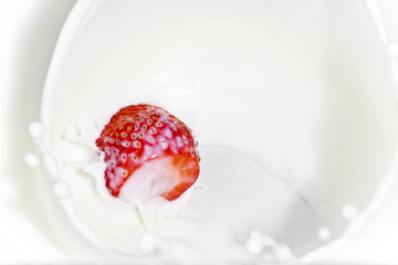 The strawberry falling in milk