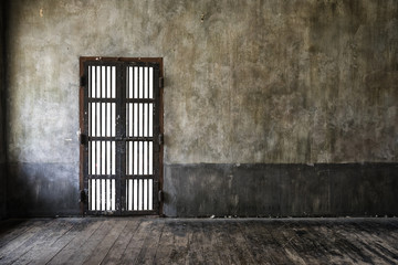 Rusted iron bars door on old wall