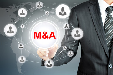 Businessman hand touching M&A (Merger and Acquisition) sign on virtual screen