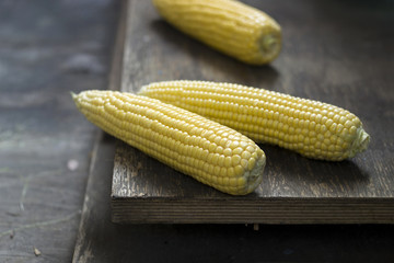 Corn cobs on wooden background