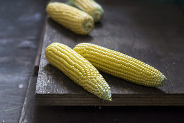 Corn cobs on wooden background