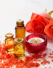 Essential oil, Mineral bath salts, candle and flowers on the wooden table.